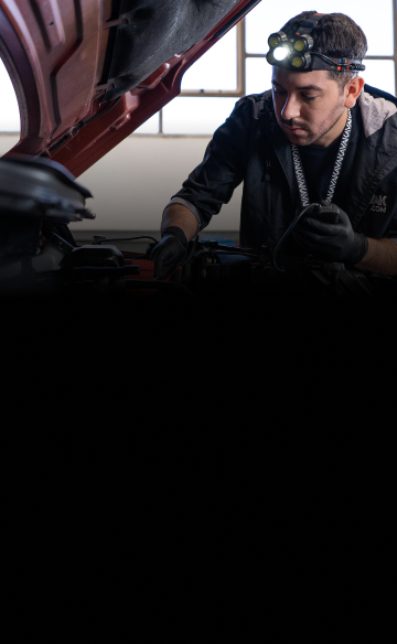 Mecánico especialista de Kavak revisa el motor de un auto durante el  service de mantenimiento.
